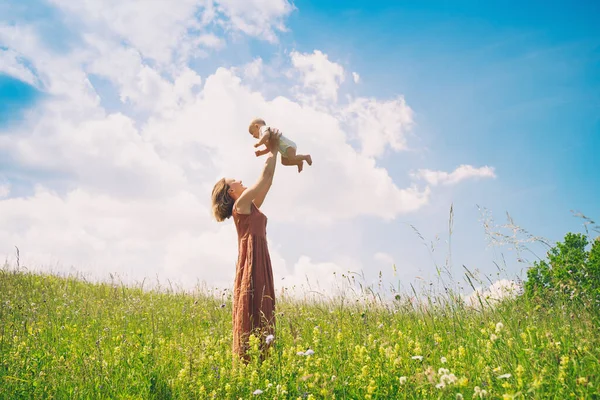 Mother and baby. Concept of natural maternity and motherhood. Beautiful woman and little baby happy together in green nature background. Loving mom with child outdoors.