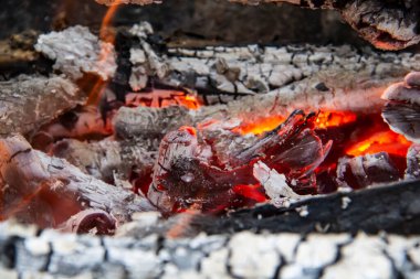 Yanan odun ateşinin kızgın közleri. Sıcak kırmızı renkte parlayan közler. Yakacak odun ızgarada yanıyor.