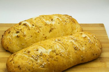 Evde un ile pişirilmiş buğday ekmeği. Ahşap tahtadaki lezzetli ekmek arka planda. GDO 'suz yemek. Baharatlı ev yapımı ekmek..