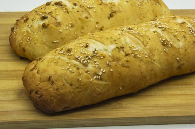 Evde un ile pişirilmiş buğday ekmeği. Ahşap tahtadaki lezzetli ekmek arka planda. GDO 'suz yemek. Baharatlı ev yapımı ekmek..