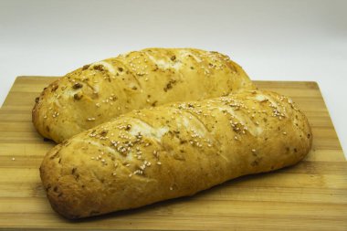 Evde un ile pişirilmiş buğday ekmeği. Ahşap tahtadaki lezzetli ekmek arka planda. GDO 'suz yemek. Baharatlı ev yapımı ekmek..