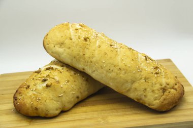 Evde un ile pişirilmiş buğday ekmeği. Ahşap tahtadaki lezzetli ekmek arka planda. GDO 'suz yemek. Baharatlı ev yapımı ekmek..