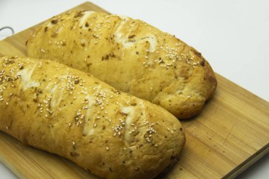 Evde un ile pişirilmiş buğday ekmeği. Ahşap tahtadaki lezzetli ekmek arka planda. GDO 'suz yemek. Baharatlı ev yapımı ekmek..