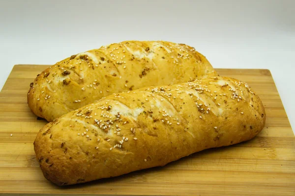 Evde un ile pişirilmiş buğday ekmeği. Ahşap tahtadaki lezzetli ekmek arka planda. GDO 'suz yemek. Baharatlı ev yapımı ekmek..