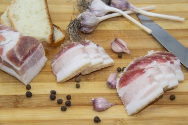 Biber ve sarımsaklı çiğ domuz yağı, bıçak, ekmek dilimleri, tahta üzerinde salo. Ukrayna geleneksel gıda konsepti.