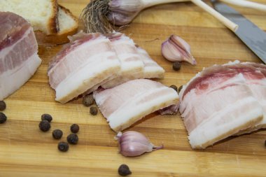 Biber ve sarımsaklı çiğ domuz yağı, bıçak, ekmek dilimleri, tahta üzerinde salo. Ukrayna geleneksel gıda konsepti.