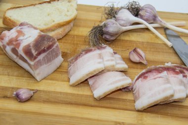 Biber ve sarımsaklı çiğ domuz yağı, bıçak, ekmek dilimleri, tahta üzerinde salo. Ukrayna geleneksel gıda konsepti.