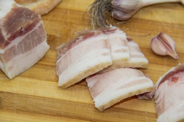 Ukrayna ürünleri çiğ domuz yağı, biber, sarımsak, bıçak, salo dilimleri ahşap tahtada duruyor. Ukrayna geleneksel gıda konsepti.