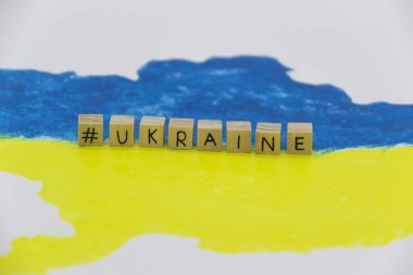 Arkaplanda tahta küplere yazılmış Ukrayna haritası mavi ve sarı renklerde.