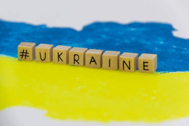 Arkaplanda tahta küplere yazılmış Ukrayna haritası mavi ve sarı renklerde.