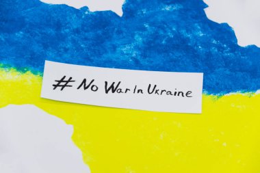 Ukrayna haritasında mavi ve sarı renkler ve üzerinde UKRAINE 'da SAVAŞ YOK yazan pankart var.