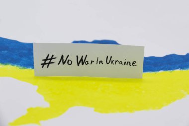 Ukrayna haritasında mavi ve sarı renkler ve üzerinde UKRAINE 'da SAVAŞ YOK yazan pankart var.