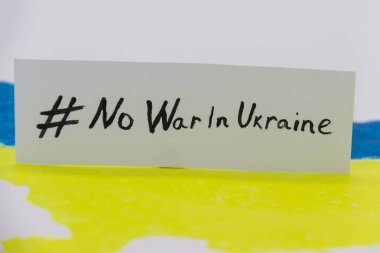 Ukrayna haritasında mavi ve sarı renkler ve üzerinde UKRAINE 'da SAVAŞ YOK yazan pankart var.