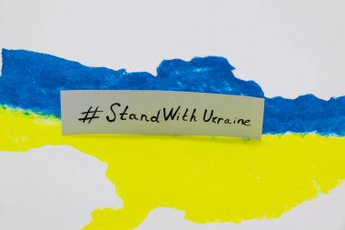 Üzerinde Ukrayna bayrağı bulunan mavi ve sarı renkli Ukrayna haritası UKRAINE ile dur.