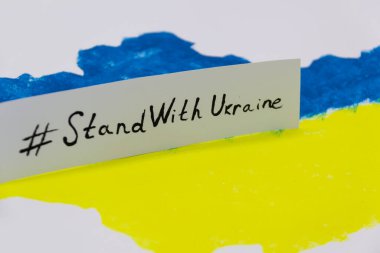 Üzerinde Ukrayna bayrağı bulunan mavi ve sarı renkli Ukrayna haritası UKRAINE ile dur.