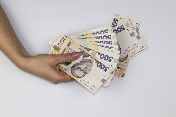 Женщины держат украинскую валюту. Несколько тысяч гривен банкнот по 500. Деньги Украины.