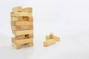 Kule tahta blok, beyaz arka plana karşı tahta bloklardan kule inşa eder. Ahşap tuğlalar rastgele duruyordu.