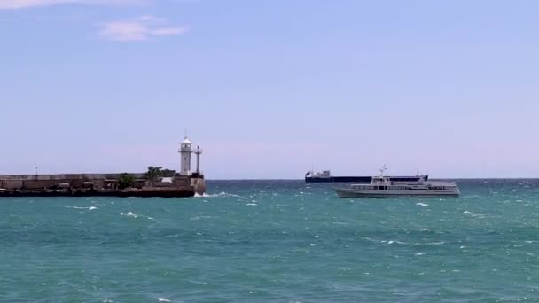 Loď se pohybuje na pozadí majáku Jalta Krym — Stock video