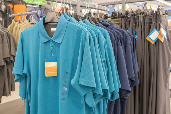 쇼핑몰에 있는 옷걸이 위에 있는 민들의 티셔츠 — 스톡 사진