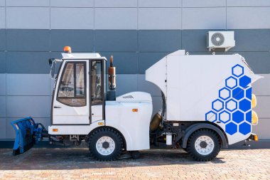 Evin önüne park edilmiş bir sokak temizleme makinesi.