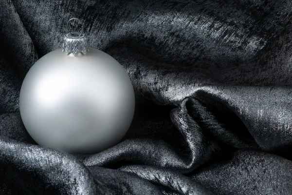 White bauble em fundo de prata metálica para o projeto do cartão de Natal — Fotografia de Stock