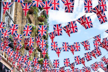 Union Jack flags on the street during queens jubilee celebration. Street party decorations in the UK city. Selective focus . clipart