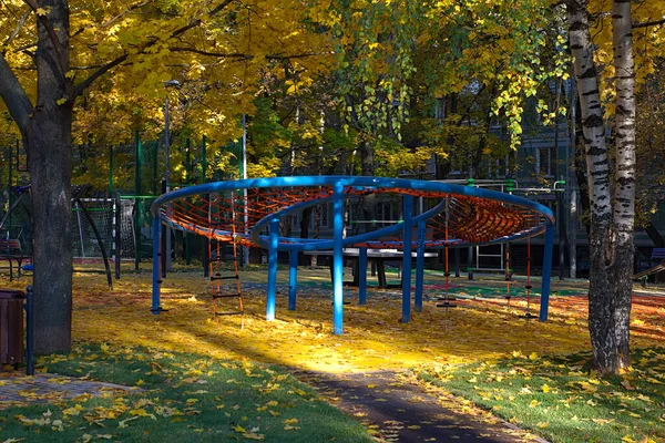 Plac Zabaw Pobliżu Domu Pokryty Jest Jesiennymi Liśćmi — Zdjęcie stockowe