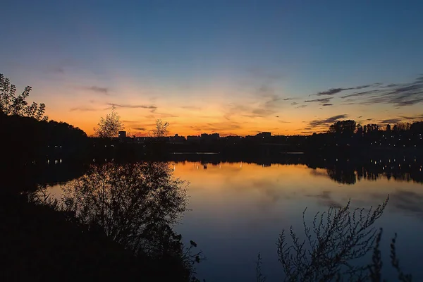 Gün Batımının Arkasındaki Gölün Yanındaki Şehrin Manzarası — Stok fotoğraf