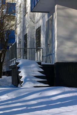 Evin girişinde karla kaplı merdivenler var.
