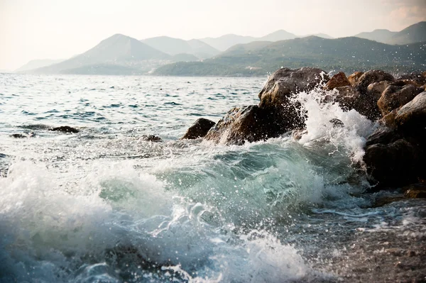 Rotsachtige kust en golven spatten Stockfoto