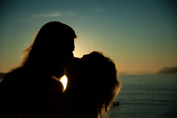 Amare coppia baciare al tramonto in spiaggia Immagini Stock Royalty Free