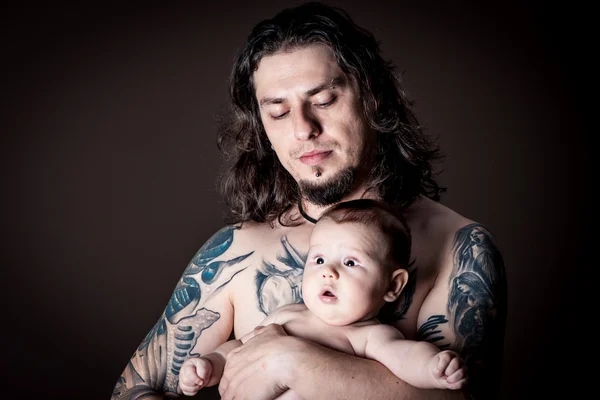 Jovem homem atraente segurando um bebê recém-nascido estúdio tiro Fotografias De Stock Royalty-Free