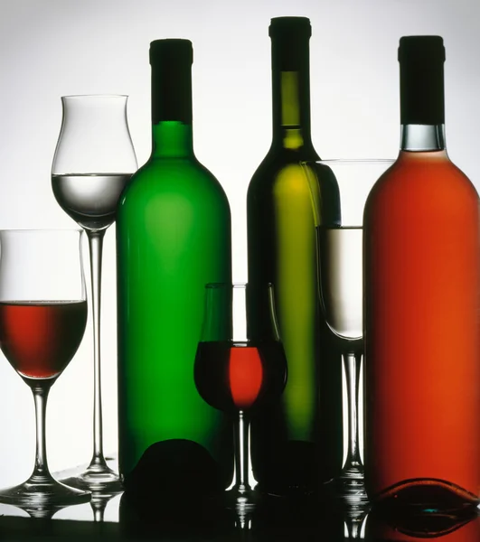 Three wine bottles and several glasses. — Stock Photo, Image