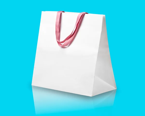 White shopping bag on light blue. — Stock Photo, Image