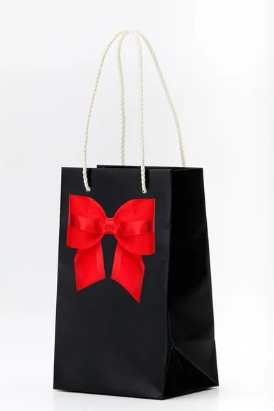 Black shopping bag with red bow — Stock Photo, Image