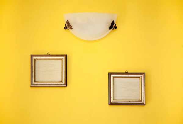 黄色の壁に 2 つの空のフレーム — ストック写真