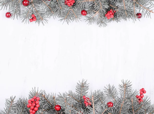 Karácsonyi üdvözlőlap. Fir ágak piros karácsonyi díszek fából készült háttér — Stock Fotó