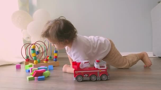 小男孩在家里地板上玩五彩缤纷的玩具。可爱的孩子玩汽车玩具 — 图库视频影像