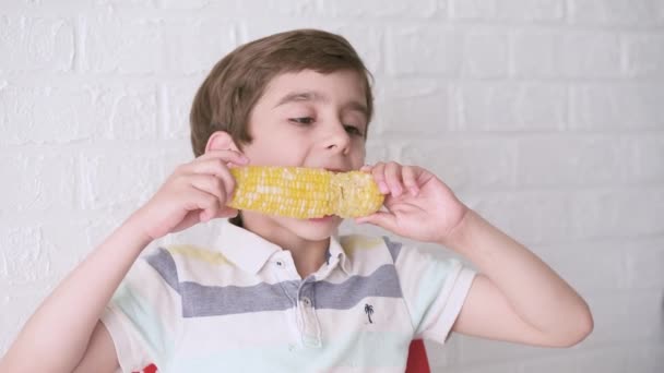 小さな空腹のかわいい男の子を閉じる喜びと甘いトウモロコシを食べる かわいい子供6歳の家庭でゆで卵を食べる 高品質のフルHd映像 — ストック動画