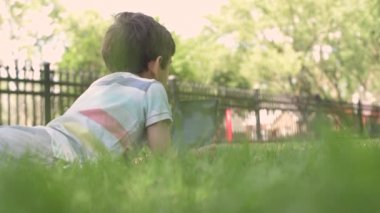 Close up Child with a tablet PC sitting on the grass outdoors