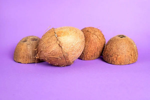 껍질을 코코넛은 반쪽으로 나누어 먹는다 색깔있는 배경에 부러진 코코넛 — 스톡 사진