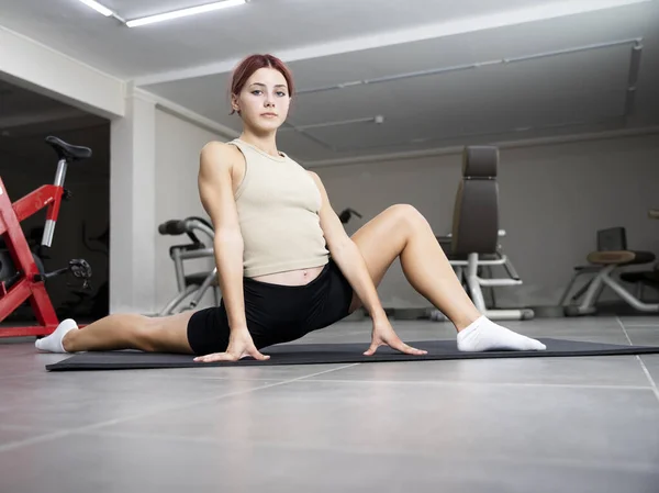 Young Girl Trains Gym Gymnast Sits Twine Mat Leg Stretch — 图库照片