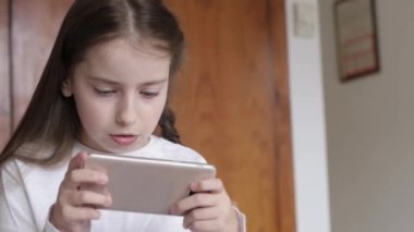 Elinde telefon olan küçük bir kız. çevrim