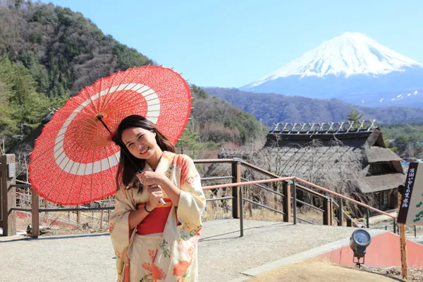 Japon kimono geleneksel kırmızı şemsiye-fuji ile arka planda kadınla