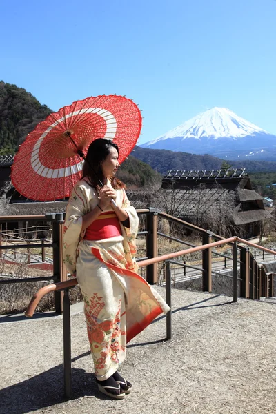 Giapponese kimono donna con tradizionale ombrello rosso con Fuji sullo sfondo — Foto Stock