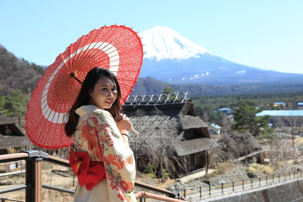 Mujer japonesa kimono con paraguas rojo tradicional con Fuji en el fondo — Foto de Stock