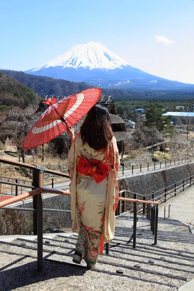 Japonské kimono žena s tradiční červený deštník s fuji v pozadí — Stock fotografie