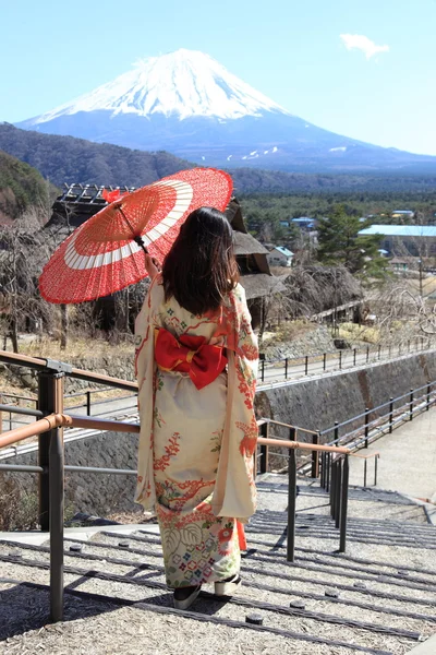 Mulher kimono japonês com guarda-chuva vermelho tradicional com Fuji no fundo — Fotografia de Stock