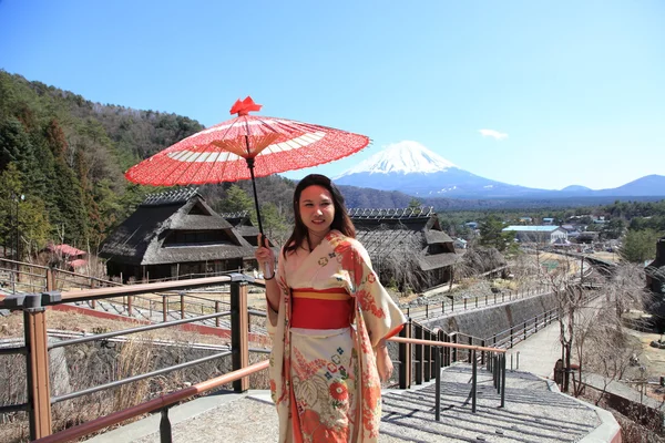 Giapponese kimono donna con tradizionale ombrello rosso con Fuji sullo sfondo Fotografia Stock