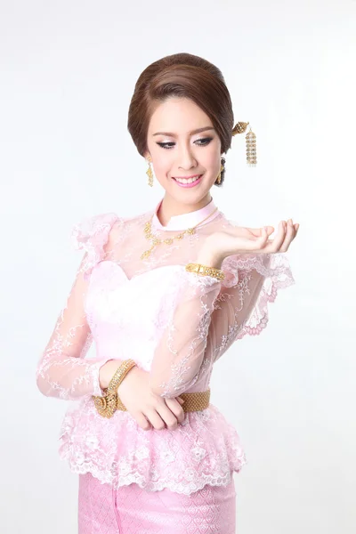Elegant fashion brunette woman posing with creative chignon hair-style and wearing pink thai dress — Stock Photo, Image